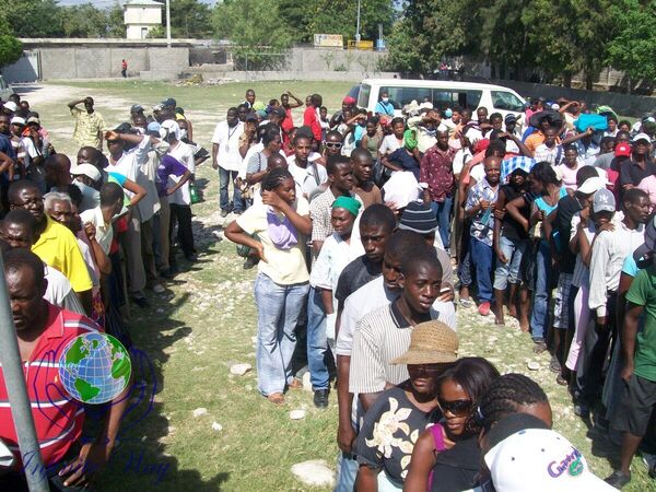 A dense crowd of Haitian community members at an outdoor clinic
