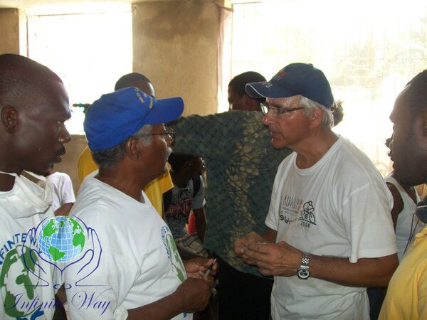 Two medical volunteers treating a patient's leg in a Haiti clinic